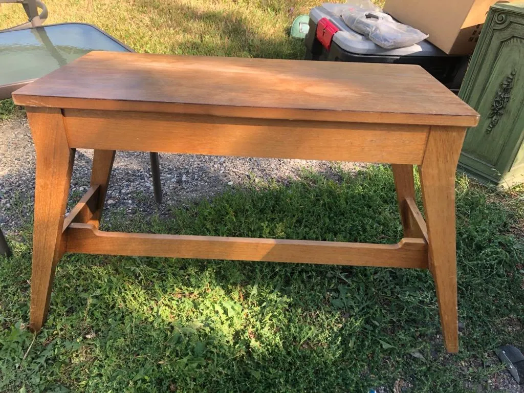 Handmade wood bench with trestle base shown outdoors