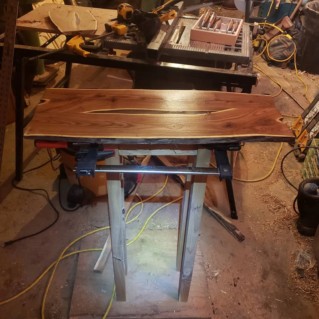 Live-edge wood slab table being built on steel hairpin legs