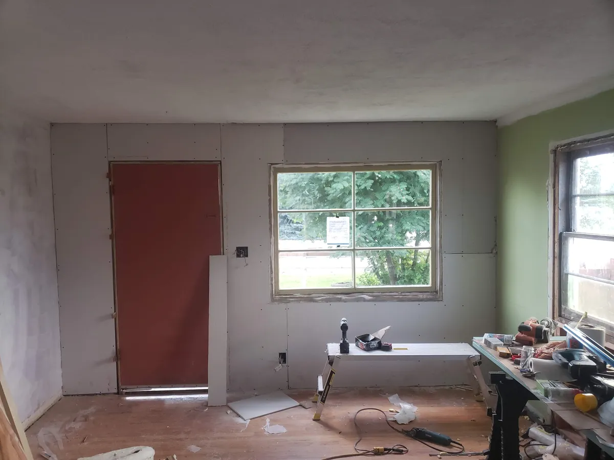 Interior drywall installation during home remodel construction phase
