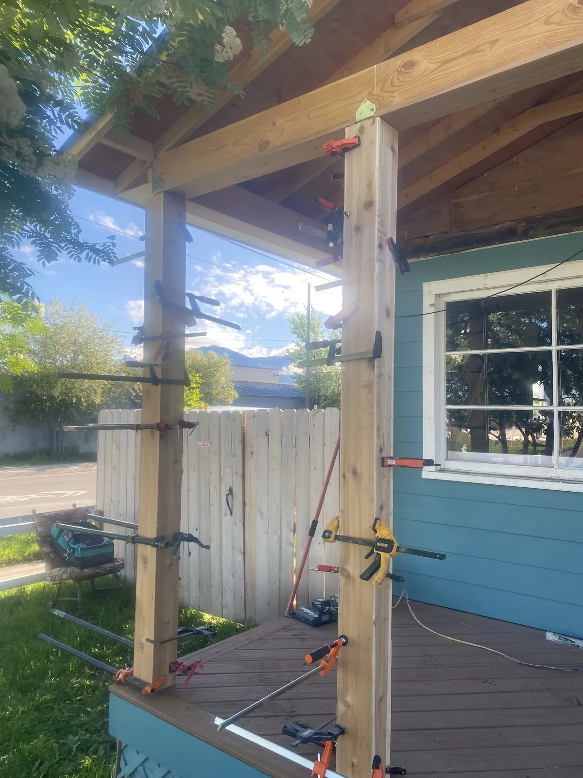 Porch post construction with bar clamps securing timber frame connections